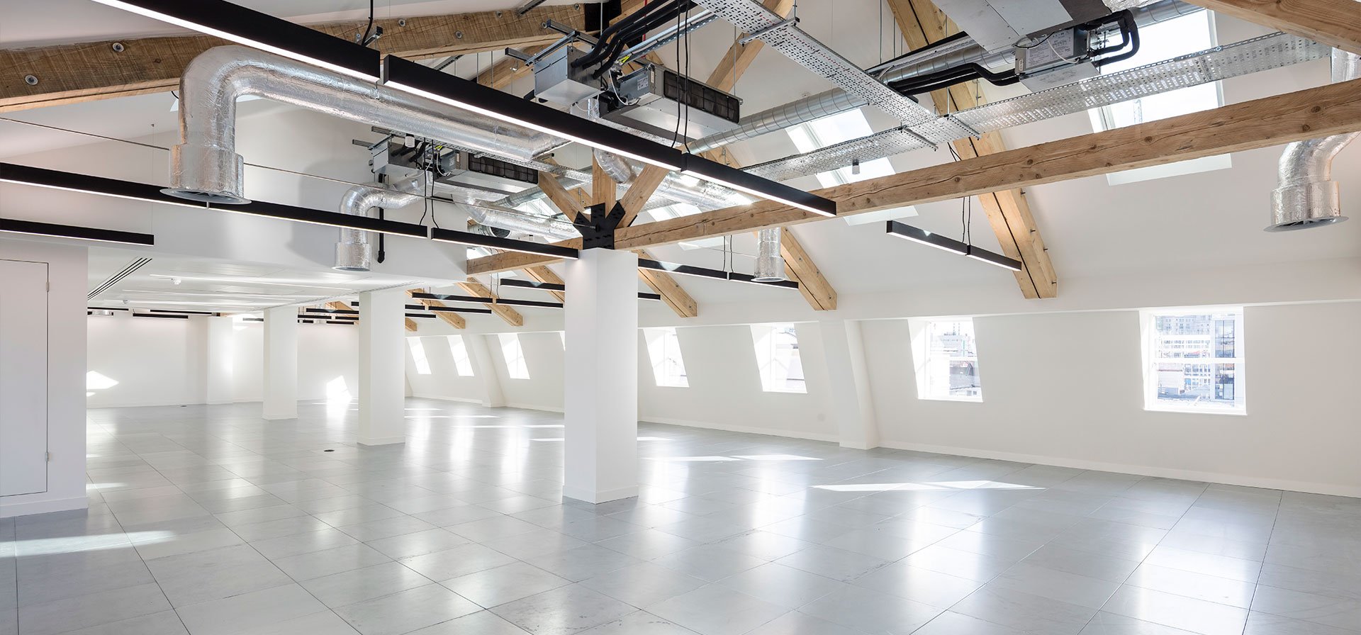45 Folgate Street open-plan office with suspended LIGHT LINE 50 under exposed timber trusses